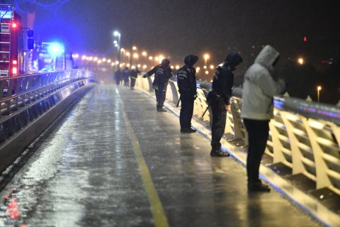 Tűzoltók és rendőrök figyelik a Dunát a Lágymányosi hídról a Parlament közelében ütközés miatt felborult és elsüllyedt Hableány rendezvényhajó utasai után kutatva 2019. május 29-én.