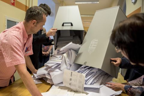A szavazatszámláló bizottság tagjai kiürítik az urnát, mielőtt megkezdik a szavazatok számlálását a szavazóhelyiség bezárása után a pécsi, Kossuth téri polgármesteri hivatalban kialakított szavazóhelyiségben, az EP-választás napján, 2019. május 26-án.