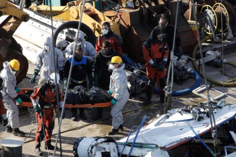 A balesetben elsüllyedt Hableány turistahajó roncsából kiemelt holttestet viszik a Margit hídnál horgonyzó uszályon 2019. június 11-én.