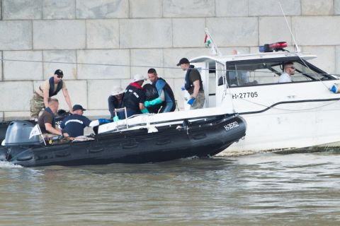 A hajóroncsból felhozott holttestet emelik át egy rendőrségi motorcsónakba a kutatási munkálatokat végző szakemberek a balesetben elsüllyedt Hableány turistahajó közelében, a Margit hídnál 2019. június 5-én.