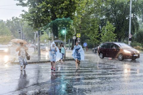 Gyalogosok futnak át az úttesten az esőben Budapesten, az Állatkerti sétányon 2017. augusztus 6-án.