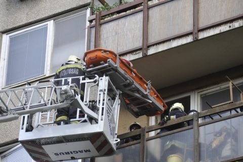 Tűzoltók emelőkosaras daruval és hordággyal mentenek egy férfit egy tízemeletes társasház negyedik emeleti lakásának erkélyéről a XIX. kerületi Zrínyi utcában 2019. augusztus 8-án.