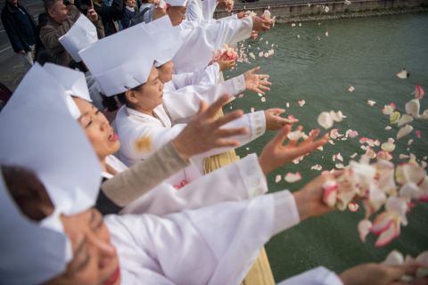 Koreai táncosok rózsaszirmokat szórnak a Dunába a Margit hídról a Hableány hajó balesetének áldozataiért tartott megemlékezésen 2019. október 7-én.