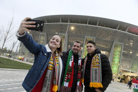 Szurkolók szelfit készítenek a Puskás Arénánál a stadion avatása előtt 2019. november 15-én.