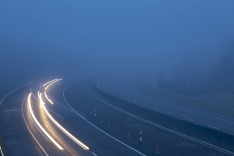 A hosszú expozíciós idővel készült felvételen az elhaladó járművek fényszóróinak fénye a sűrű ködben az M7-es autópályán Nagykanizsa közelében 2019. december 7-én.