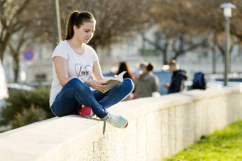 Pólóban olvas egy nő az enyhe időben egy győri parkban 2019. december 18-án.
