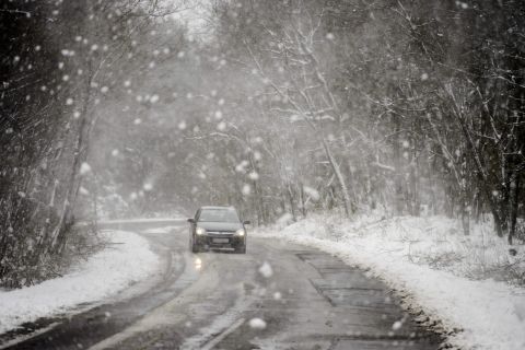 Egy autó halad a havazásban a Heves megyei Bátor közelében 2020. március 23-án.
