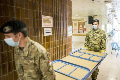 Katonák tábori ágyakat pakolnak a Pécsi Tudományegyetem Akác utcai klinikai tömbjében 2020. április 20-án.