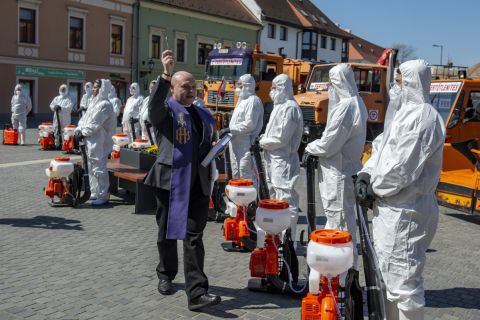 Czibere Zsolt plébániai kormányzó megáldja a vegyszeres fertőtlenítést végző szakembereket és eszközeiket az egri Gárdonyi Géza téren a koronavírus-járvány idején, 2020. április 2-án.
