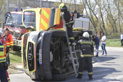 Tűzoltók felborult mentőautónál a főváros XIV. kerületében, az Egressy út és Miskolci utca kereszteződésében 2020. április 8-án.