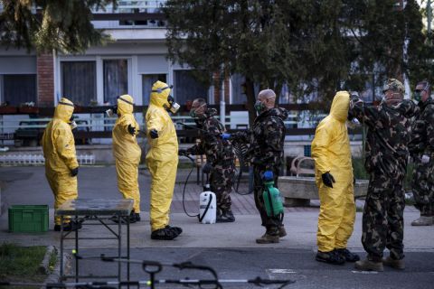 Védőruhába öltözött katonák ruházatát fertőtlenítik a fővárosi önkormányzat Pesti úti idősotthonában 2020. április 17-én.