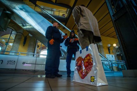 Rendőrök megbírságolnak egy 65 év alatti férfit a budapesti Fővám téri központi vásárcsarnokban 2020. április 9-én, mert 9 és 12 óra között csak a 65 felettiek vásárolhatnak.
