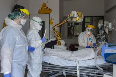 Védőfelszerelést viselő orvos és ápolók ellátnak egy beteget a koronavírussal fertőzött betegek fogadására kialakított osztályon a fővárosi Szent László Kórházban 2020. május 8-án.