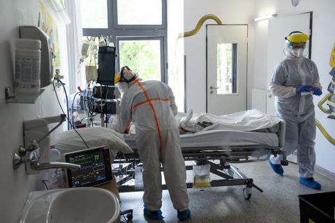 Védőfelszerelést viselő orvos és ápoló ellát egy beteget a koronavírussal fertőzött betegek fogadására kialakított osztályon a fővárosi Szent László Kórházban 2020. május 8-án.