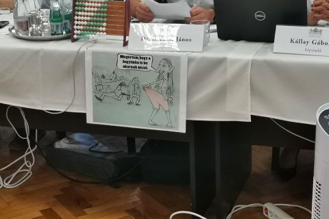 A fideszes Bácskai János hirdeti a keresztény, konzervatív humort az asztalára akasztott karikatúrával.
