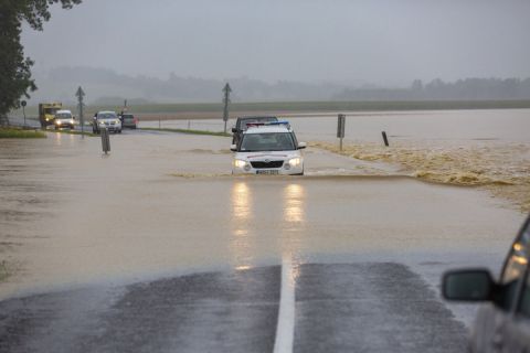 A katasztrófavédelm gépjárműve és egy terepjáró halad a nagy esőzés miatt vízzel elárasztott Csurgót és Gyékényest összekötő úton, a Somogy megyei Porrogszentkirály közelében 2020. július 25-én.