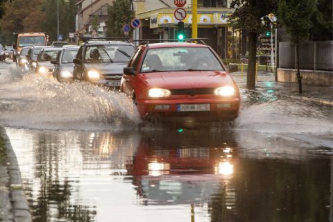 Személyautók haladnak a heves zápor után esővízzel borított győri Mónus Illés utcában 2020. augusztus 17-én.