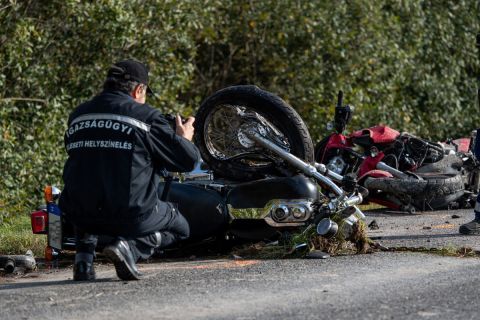 Összeroncsolódott motorkerékpárok mellett helyszínel egy rendőr az 51-es főút 140-es kilométerénél, Dusnok közelében 2020. október 23-án, miután egy autó összeütközött a két motorkerékpárral. A két motoros a helyszínen meghalt.