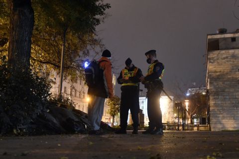 Rendőrök igazoltatnak a koronavírus-járvány második hulláma miatt elrendelt kijárási tilalom idején a belvárosi Erzsébet téren 2020. november 11-én.