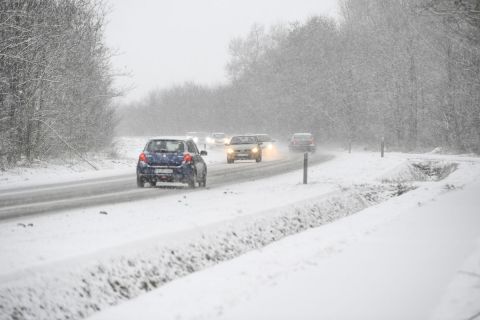 Járművek haladnak a sűrű hóesésben a 471-es főúton Nyíradony közelében 2021. január 15-én.
