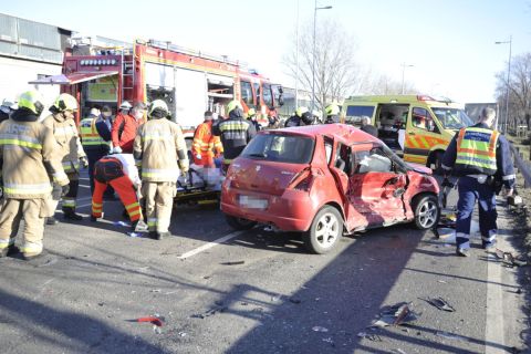 Hordágyon visznek egy sebesültet a mentőautóhoz a Ferihegyi Repülőtérre vezető úton, ahol három személyautó és egy kisteherautó ütközött össze 2021. március 3-án.