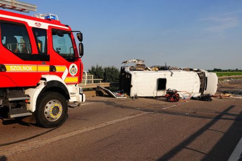 Ütközésben összetört kisbusz a 4-es főút 92-es kilométerénél, Szolnoknál 2021. június 4-én. A jármű egy kamionnal ütközött össze. A balesetben hárman meghaltak és tizenhárman megsérültek.