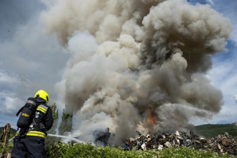 Tűzoltó egy kigyulladt salgótarjáni MÉH-telep oltásán 2021. július 4-én.