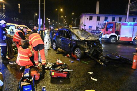 Mentők sérültet ápolnak összeroncsolódott személygépkocsi mellett a IX. kerületi Soroksári út és a Kvassay Jenő út kereszteződésében, ahol a gépjármű és egy nyerges vontató ütközött 2023. január 15-én. A balesetben egy ember meghalt, három pedig megsérült.