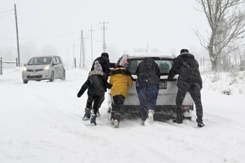 A havas úton elakadt autót tol egy család a behavazott Bakonyban, Tés határában 2023. január 22-én.