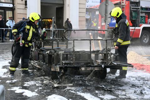 Kiégett elektromos városnéző kisbusz oltásának utómunkálatain dolgoznak tűzoltók a főváros I. kerületében, a budavári Dísz téren 2023. december 11-én.