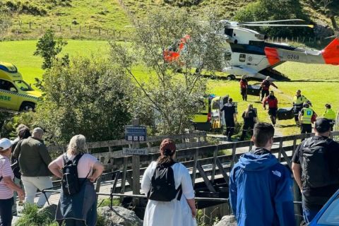 Bámészkodók és mentőhelikopter a baleset helyszínén.