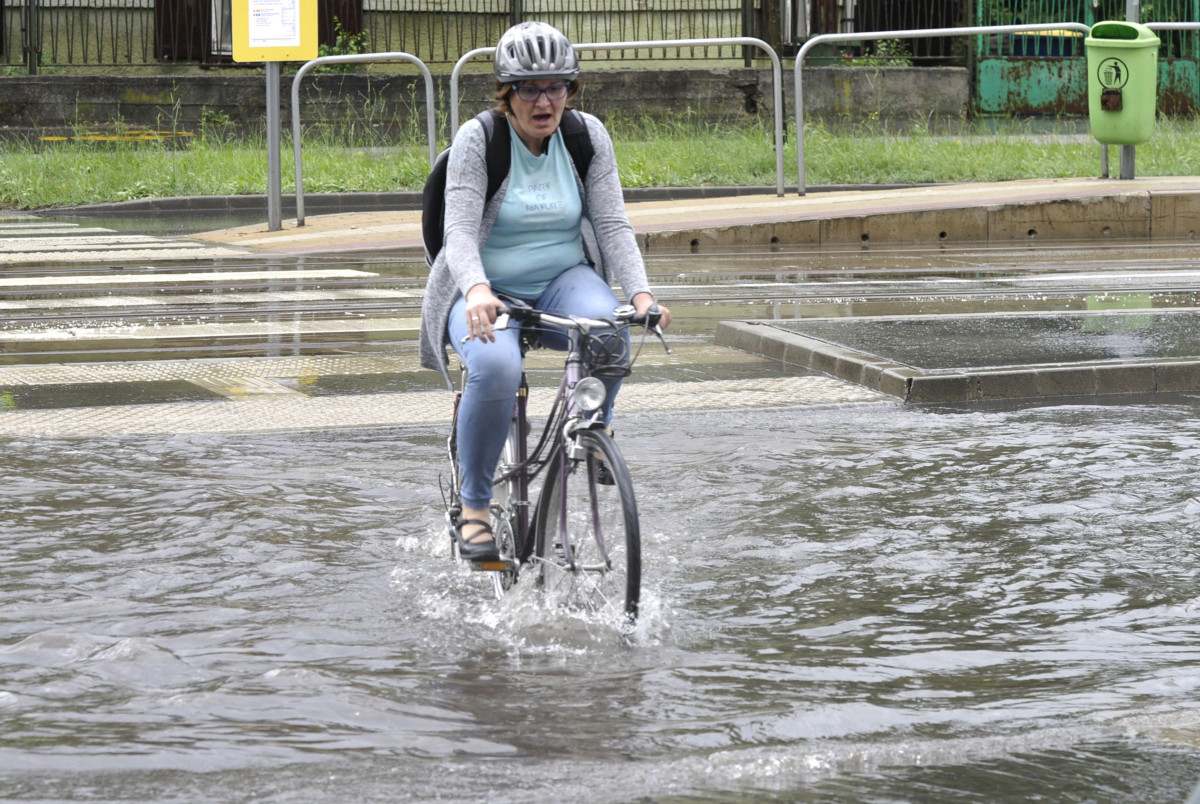 Kerékpáros halad a hirtelen jött felhőszakadás miatt vízzel borított XIX. kerületi Ady Endre úton 2019. május 29-én.