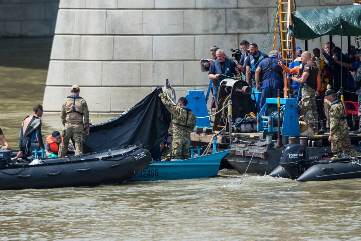 A hajóroncsból felhozott holttestet takarják el a kutatási munkálatokat végző szakemberek a balesetben elsüllyedt Hableány turistahajó közelében, a Margit hídnál kiépített pontonnál 2019. június 4-én.