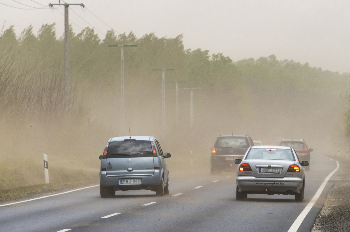 Autók haladnak a 4-es számú főúton, Nyírpazony és Nyírtura között, miközben homokot fúj a viharos szél 2020. április 25-én.