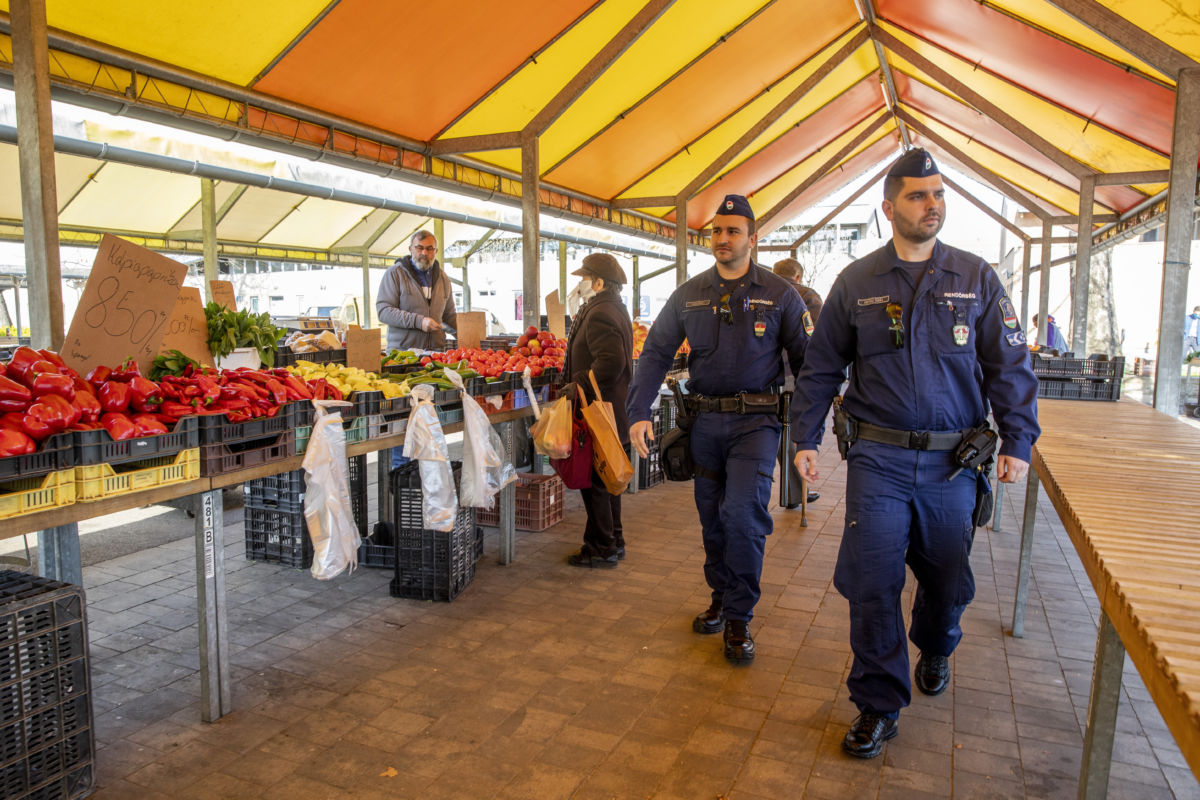 Rendőrök járőröznek a szegedi Mars téri piacon 2020. április 6-án.