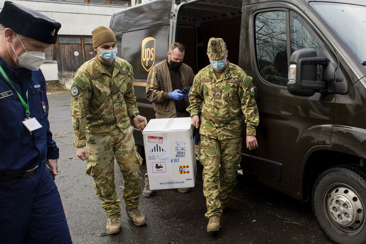 A győri Petz Aladár Megyei Oktató kórházba érkezett Pfizer-BioNTech vakcinákat tartalmazó dobozt katonák viszik 2020. december 30-án.