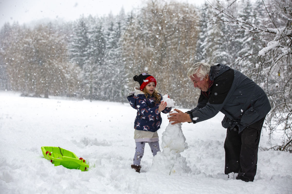 Hóembert épít egy férfi unokájával havazás után Zalaegerszegen 2021. január 8-án.