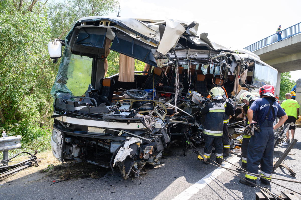 Tűzoltók az árokból kiemelt, hajnalban balesetet szenvedett autóbusznál az M7-es autópálya mellett Szabadbattyán közelében 2021. augusztus 15-én.