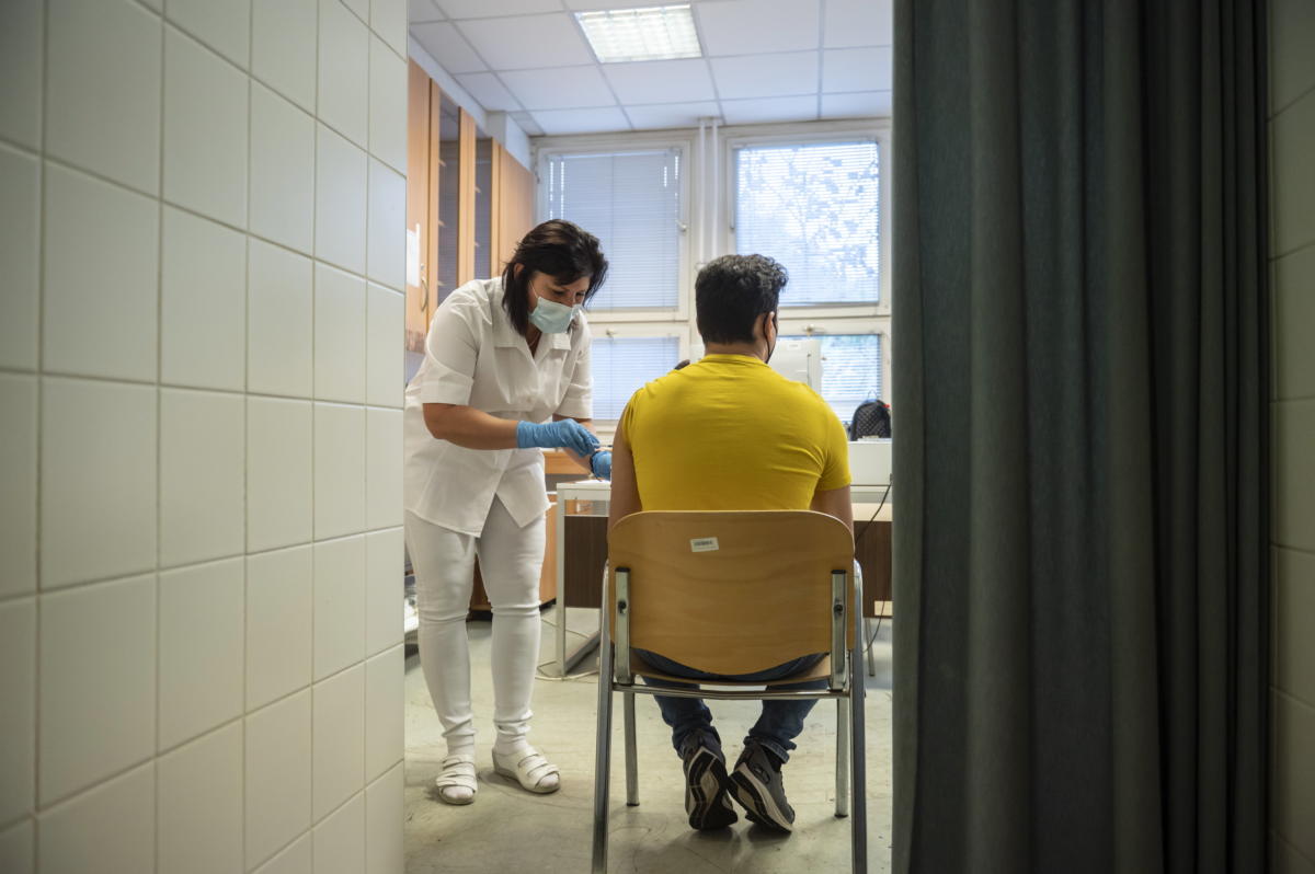 Beoltanak egy férfit a német-amerikai fejlesztésű Pfizer-BioNTech koronavírus elleni oltóanyag, a Comirnaty-vakcina harmadik, emlékeztető adagjával a salgótarjáni Szent Lázár Megyei Kórház oltópontján 2021. november 4-én.