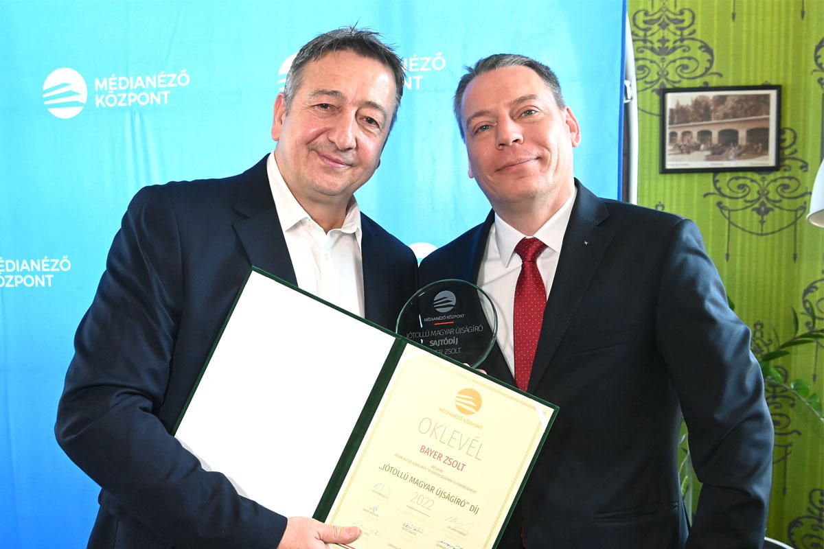 Bayer Zsolt, a Magyar Nemzet publicistája (b), miután átvette a Médianéző Központ által alapított Jótollú magyar újságíró díjat Boros Bánk Leventétől, a Médianéző Központ igazgatójától (j) a Városliget Caféban 2022. március 10-én.
