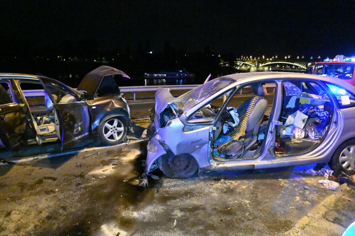 Összeroncsolódott személygépkocsik Budapesten, a Slachta Margit rakparton, a Margit híd közelében, miután frontálisan ütköztek 2022. július 29-én. A balesetben négyen megsérültek.